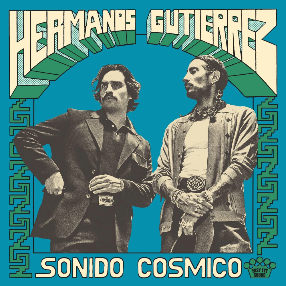Duotone photo of two Ecuadorian men, silhouetted over a blue background. One has a moustache and scruffy hair. He is wearing a suit coat over a polo and pants with a large belt buckle. He’s reaching into his pocket and looking off into the distance behind the camera. The second has a moustache, short beard, and long hair in two braids set from behind his head. He’s wearing a light pattern sweater, open over a t-shirt, with sleeves rolled up to reveal tattoos, and pants with a large belt buckle. He’s holding a hat with his other hand holding the first. They’re covered in bracelets and rings. There is an Ecuadorian pattern used for side borders. The band name is set in a comic-book style 3D font. The record title is set in a simple artistic font.